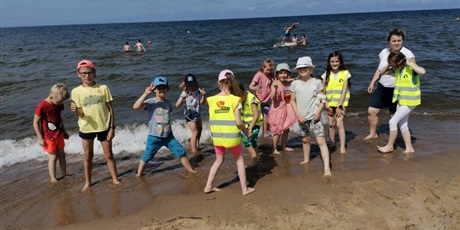 Powiększ grafikę: Grupa dzieci bawiąca się na brzegu morza.