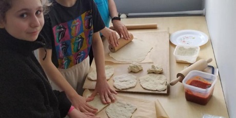 Powiększ grafikę: Klasa 6 w szkolnej kuchni podczas samodzielnego przygotowywania i pieczenia pizzy.