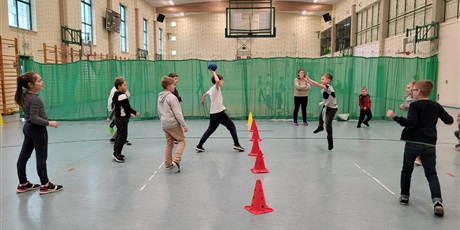 Powiększ grafikę: Uczniowie na sali gimnastycznej podczas zajęć sportowych.