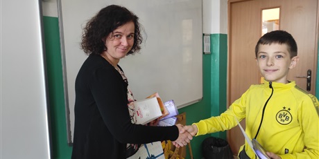 Powiększ grafikę: Pani Justyna Kuczyńska wręcza nagrodę uczniowi z klasy 4B