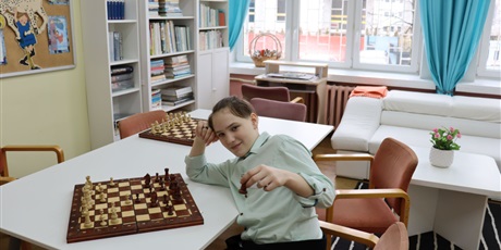 Powiększ grafikę: Na zdjęciu  Paweł uczeń klasy szóstej podczas przerwy w partyjce szachów.